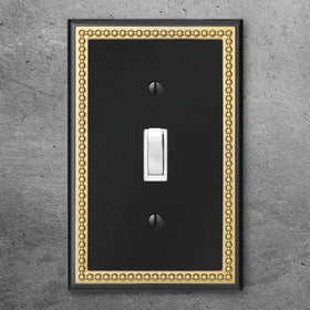 Henne Bery pearled-frame outlet cover in dark golden complements upscale interiors.