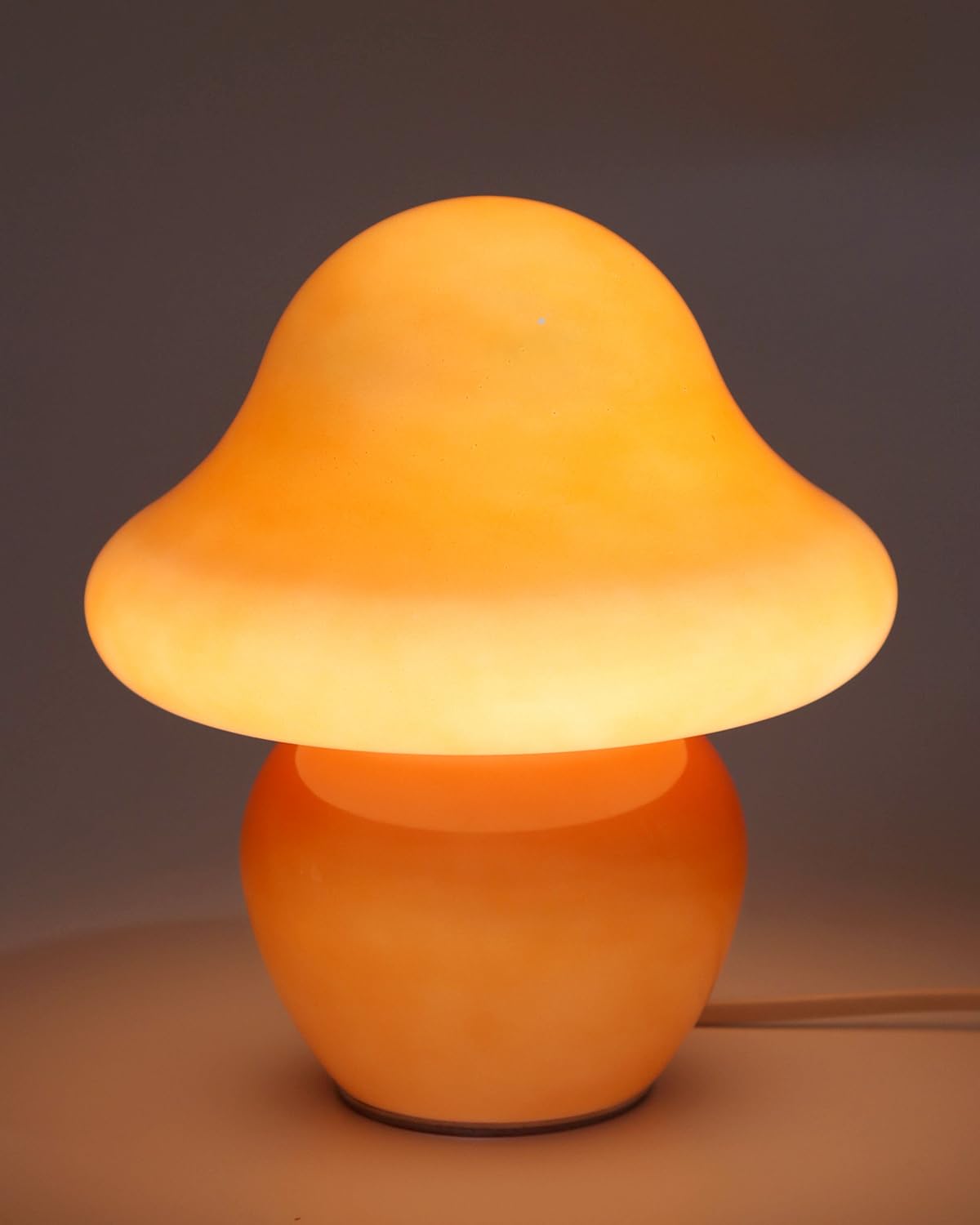 HEQET mushroom lamp with orange glass shade provides cozy bedside lighting.