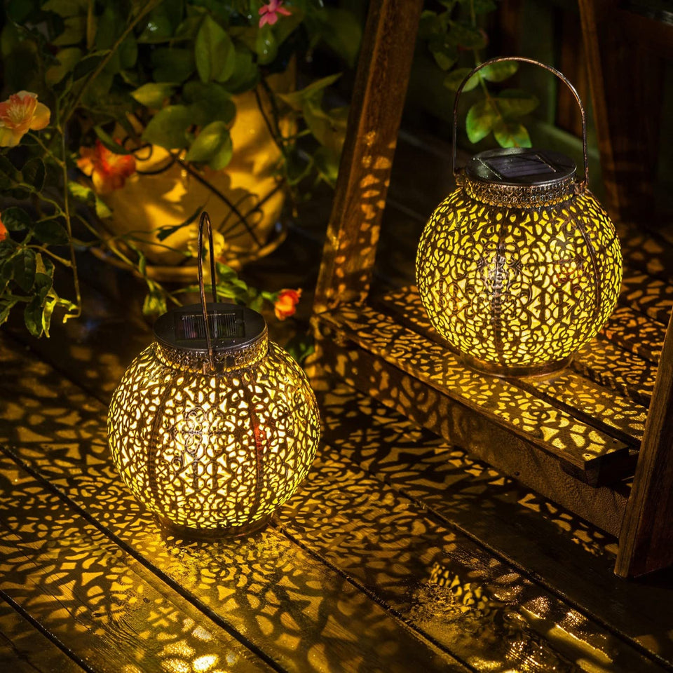 HOMEIMPRO rose lantern pattern casting warm light on outdoor table setting.