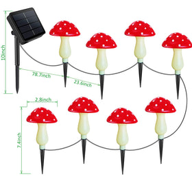 Homeleo red mushroom solar light among flowers highlighting decorative accents at night.