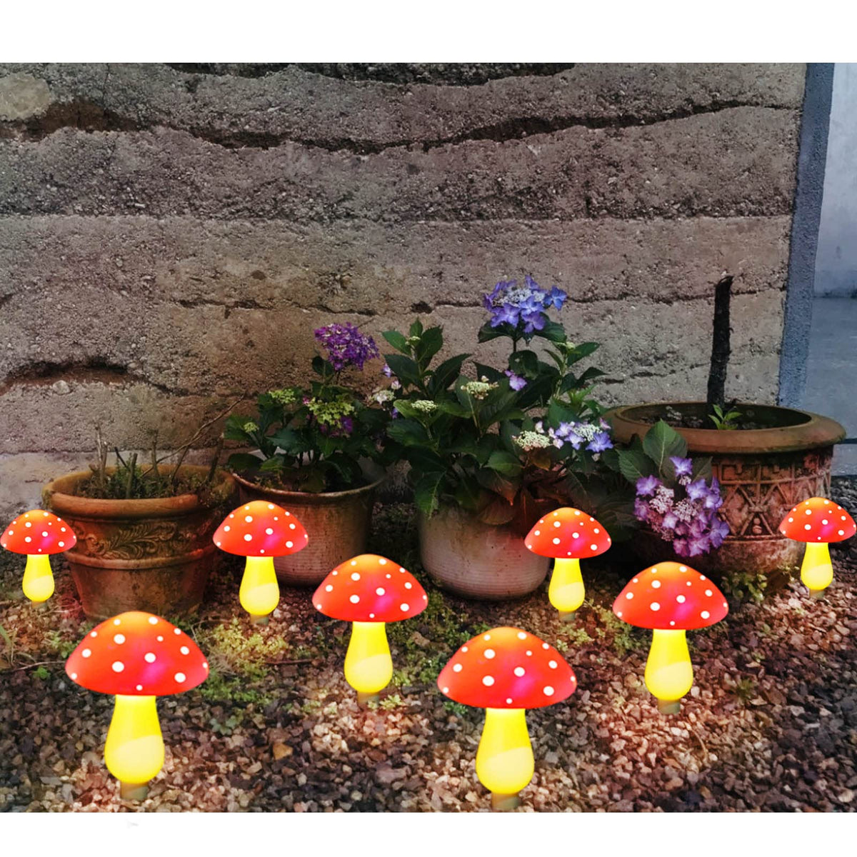 Homeleo red mushroom solar light glowing softly during a dusk garden gathering.