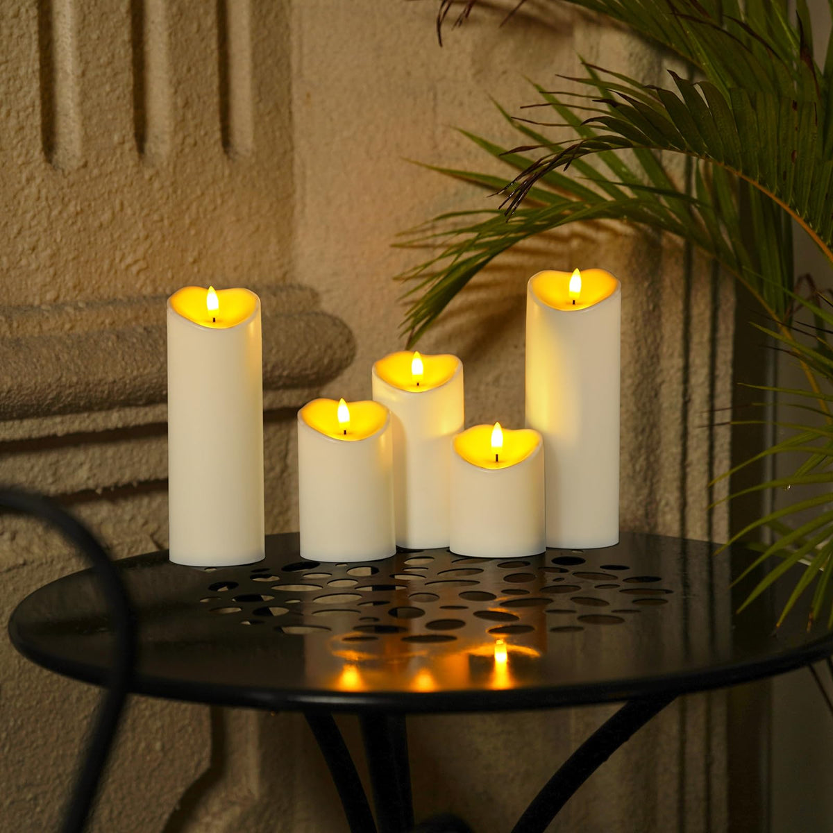 Homemory outdoor candles glow softly on tabletops and patios.