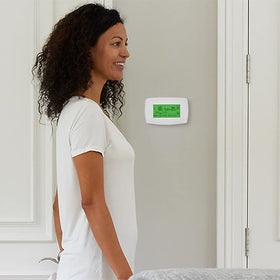 Close-up of the RTH7600D display highlighting scheduling capability for precise temperature control.