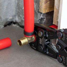 PEX pipe connected to brass fitting with copper crimp ring using IWISS