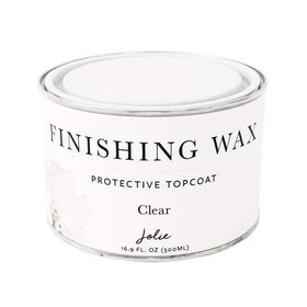 Jolie Finishing Wax clear bottle closeup showing odor-free protection for furniture.