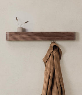 Kazai Toke wall-mounted coat rack with walnut veneer for a sleek entryway.