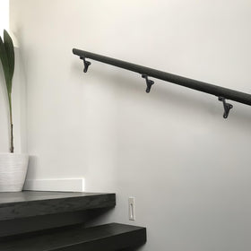 Khtumeware matte black finish bracket highlighting modern decor while supporting handrails.