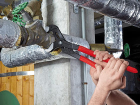 KNIPEX Cobra XXL pliers with self-locking teeth gripping round pipe securely.