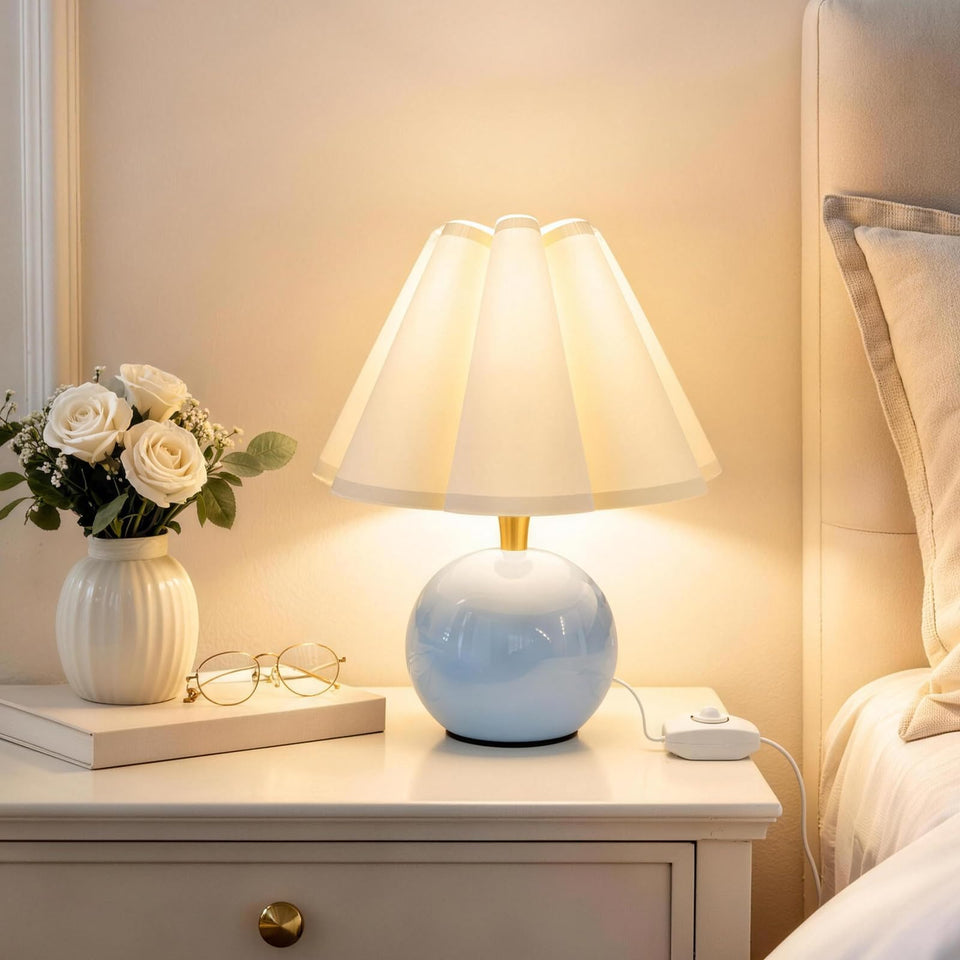 Komothala bedside lamp with ceramic base provides a warm ambient glow for nighttime reading.