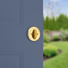 Kwikset 660 deadbolt keyway close-up in polished brass for reliable access.