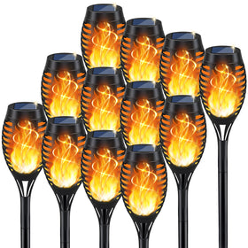 KYEKIO solar torch light with flickering flame illuminating a garden path at dusk.