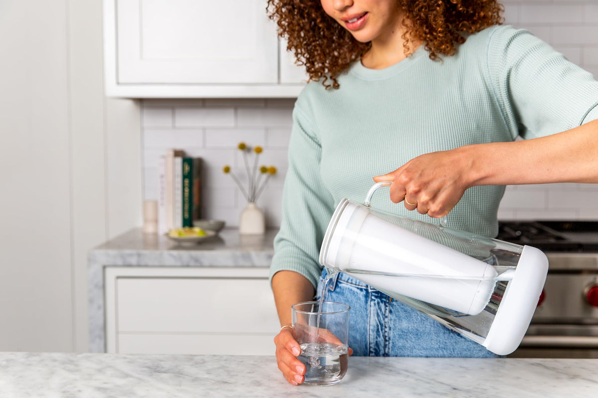 LifeStraw Home pitcher shown while dispensing crisp, filtered water at home