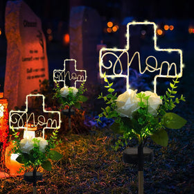 Lmtocs solar cross memorial light illuminating the headstone all season.