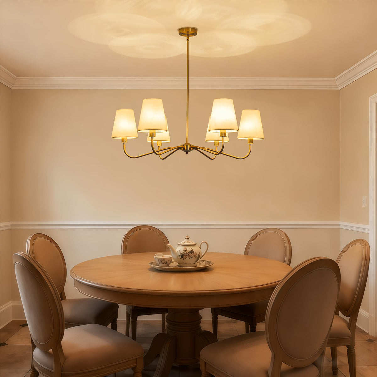 LOZOHOM brass gold chandelier in dining room with soft, diffused lighting.