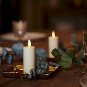 Luminara ivory votives tucked into garlands for festive decor.