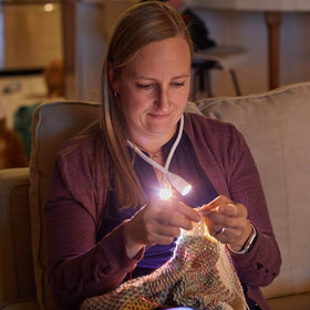 Lumos Knitting Light around the neck is travel-ready for planes, trains, and cars.