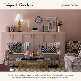 MacKenzie-Childs lamp with brass accents and bell shade enhances ambient lighting.