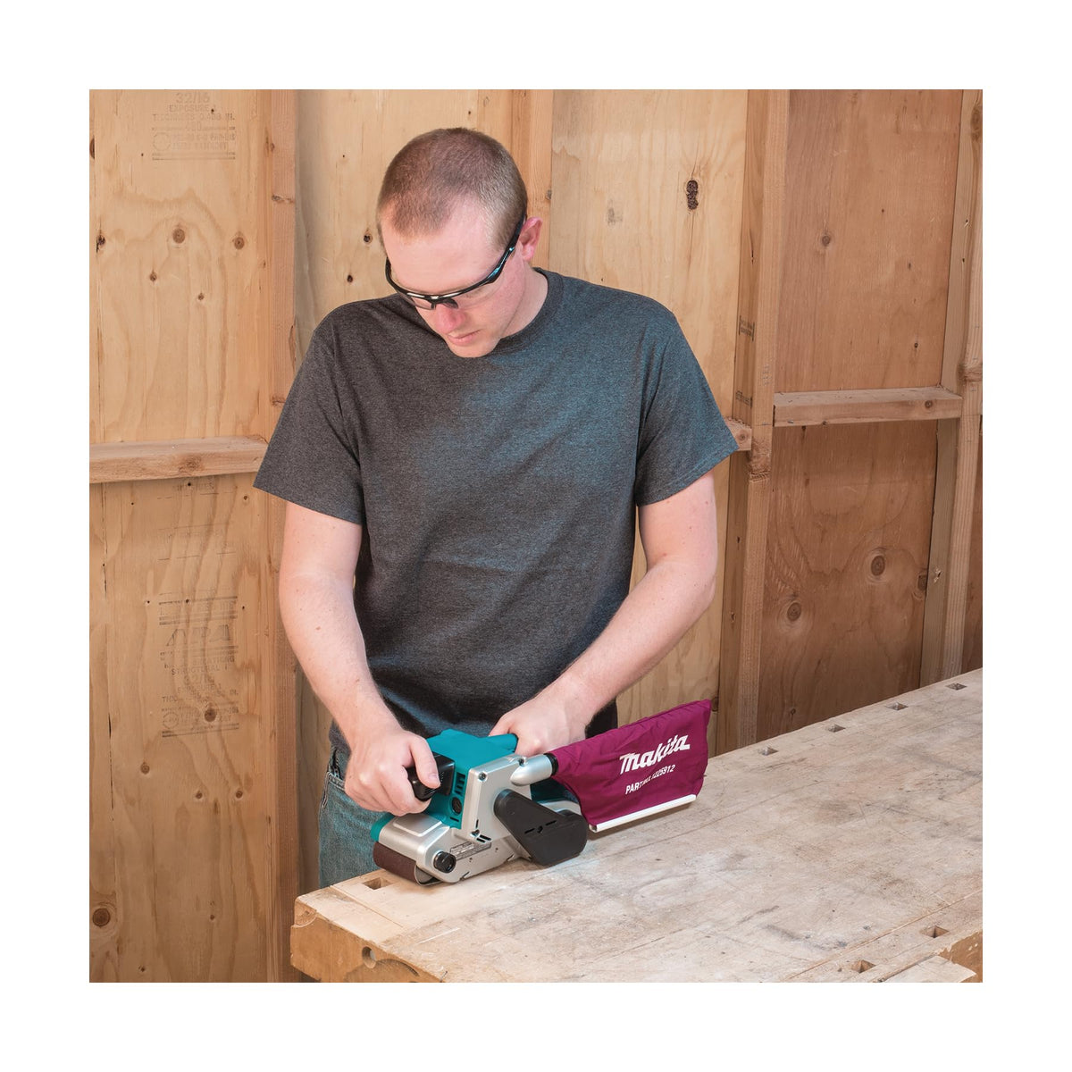 Makita 9903 in use on a wood panel for smooth surface prep.