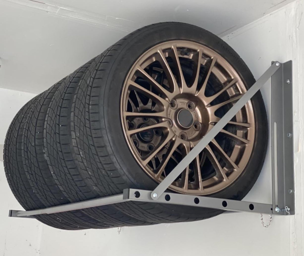 MaxxHaul adjustable-width tire rack adapts to various tires and stud layouts for versatile storage.