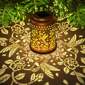 Miggley hummingbird outdoor solar lantern front view with warm garden glow.