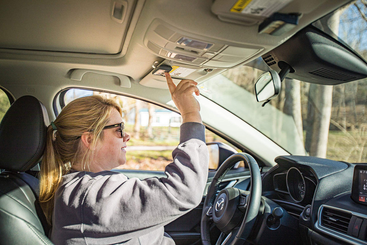 Mighty Mule MMT103 remote shown with visor clip for hands-free mounting.