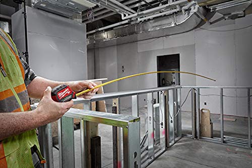 User measuring with Milwaukee 25 ft tape measure in a workshop setting.