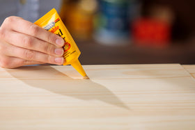 Minwax stainable wood filler application with putty knife demonstrates patch placement.