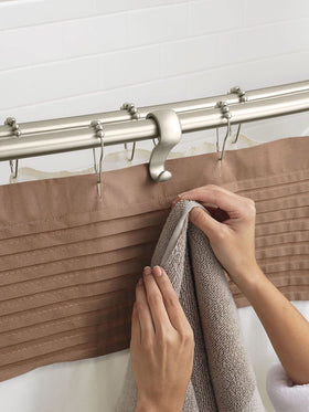 Moen curved rod installed in a bathroom setup with wall brackets