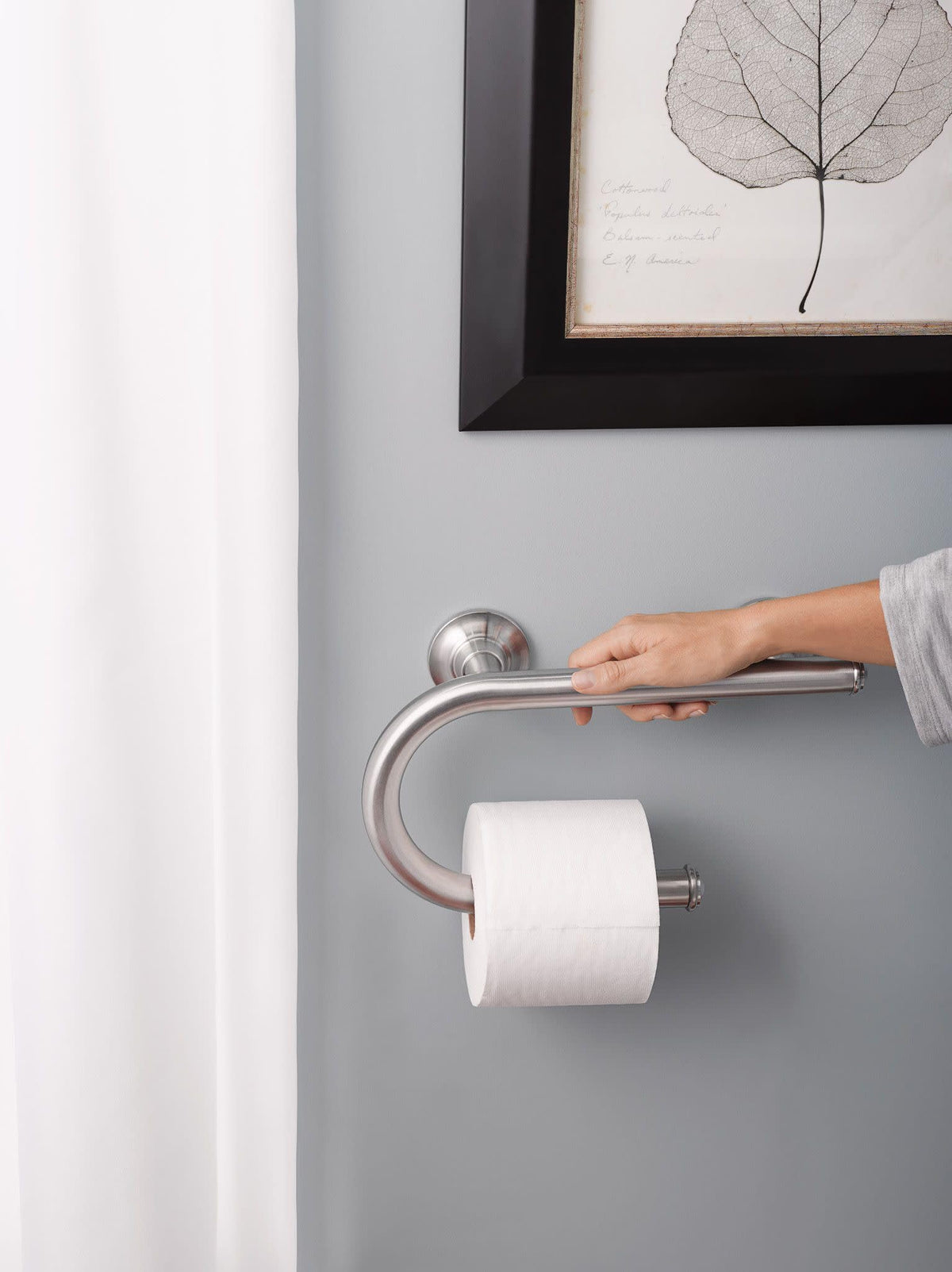 Moen brushed nickel grab bar with integrated toilet paper holder for convenience