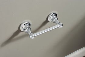 Moen Vale chrome wall-mounted toilet paper holder for a clean bathroom look.
