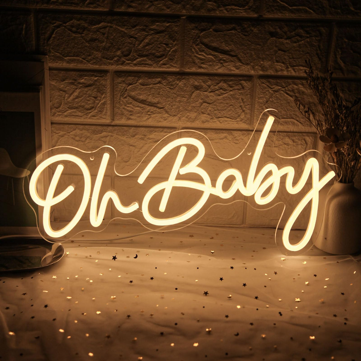 Mojoish Oh Baby neon sign backdrop setup adds warm lighting for celebrations.