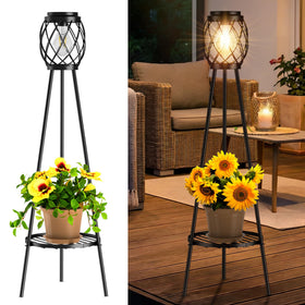 MXwcy solar floor lamp with plant stands lighting a garden path with warm ambient glow