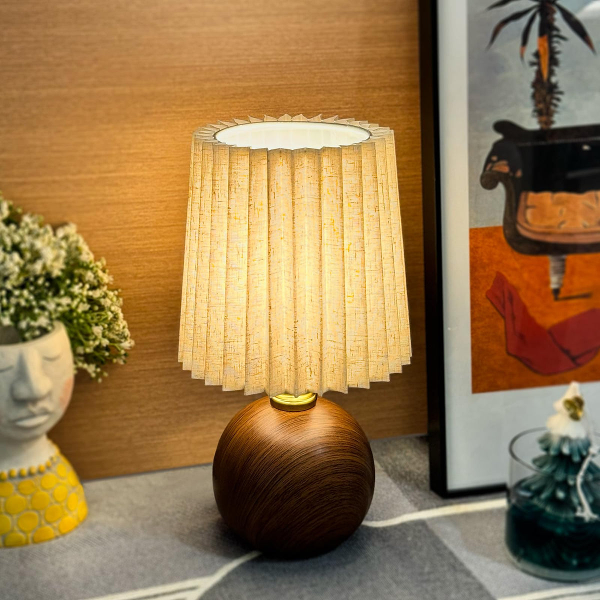 Nomoluke small pleated table lamp base ceramic with wood grain texture provides sturdy bedside lighting for reading.