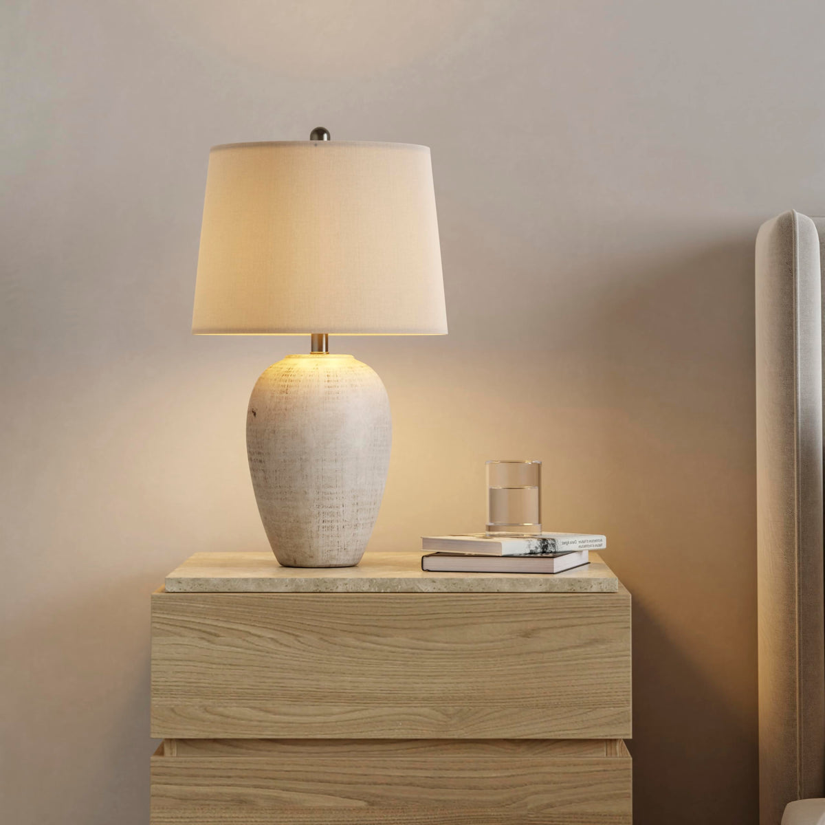 Nourison Home ceramic jar lamp with ivory shade creates cozy bedroom ambience.