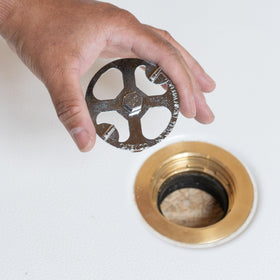 Oatey 42239 wrench in use during shower drain installation.