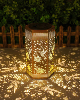 Opjoy hummingbird solar lantern in garden glows warmly for outdoor evenings.