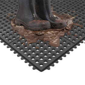 Ottomanson waterproof mat shown being hose-cleaned for fast maintenance.