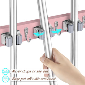 Close-up of pink wood panel with stainless steel clips securing mop handles