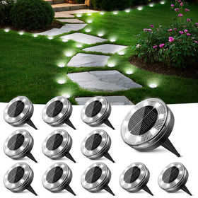 Peasur flat solar disc light illuminating a narrow garden path