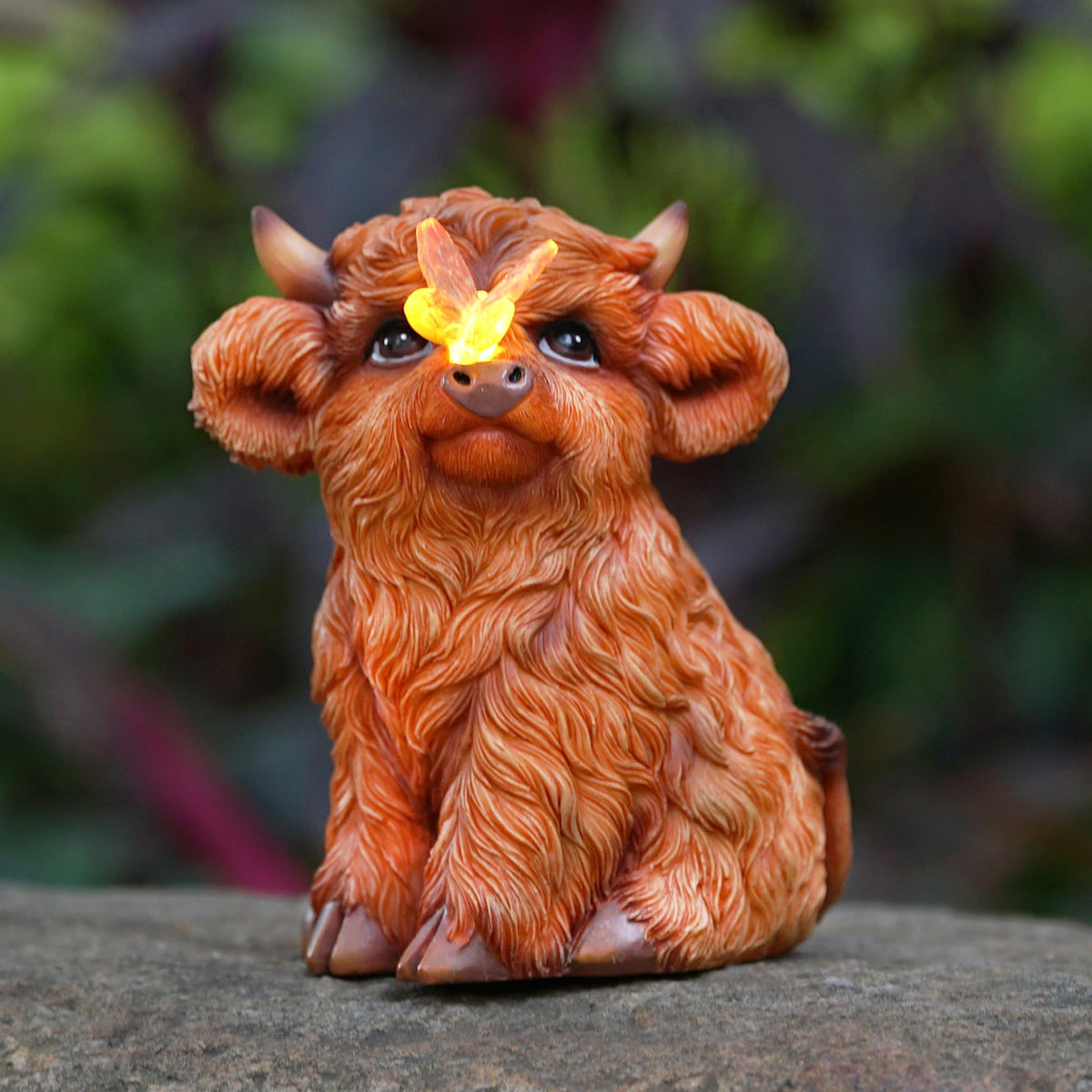 Roundot Highland Cow statue lit at dusk for cozy outdoor ambiance