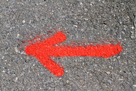 Fluorescent red-orange marking spray marking outdoor field and lot lines.