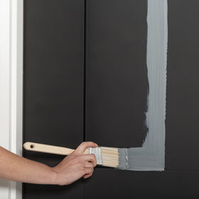 Rust-Oleum brush-on application on a door edge demonstrates easy, low-odor use