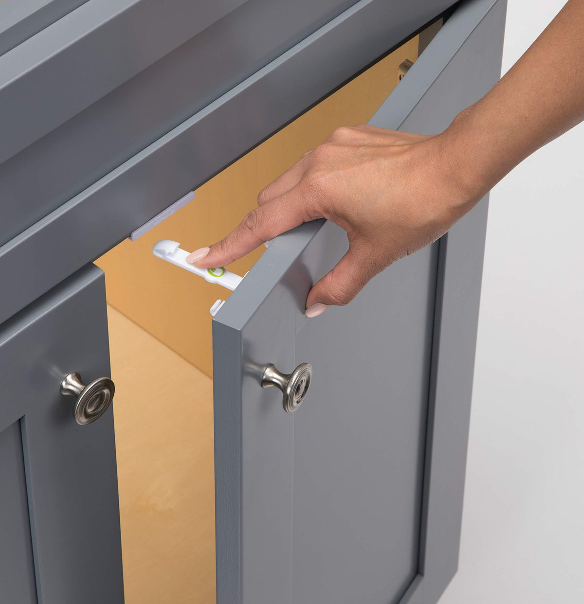 Safety 1st adhesive cabinet latch close-up demonstrates peel-and-stick installation for renters.