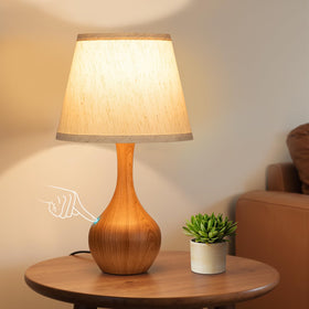 Seealle touch table lamp with wood base providing warm bedside glow.