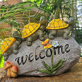 Shumi solar garden statue turtle glowing on rock to welcome guests at night.