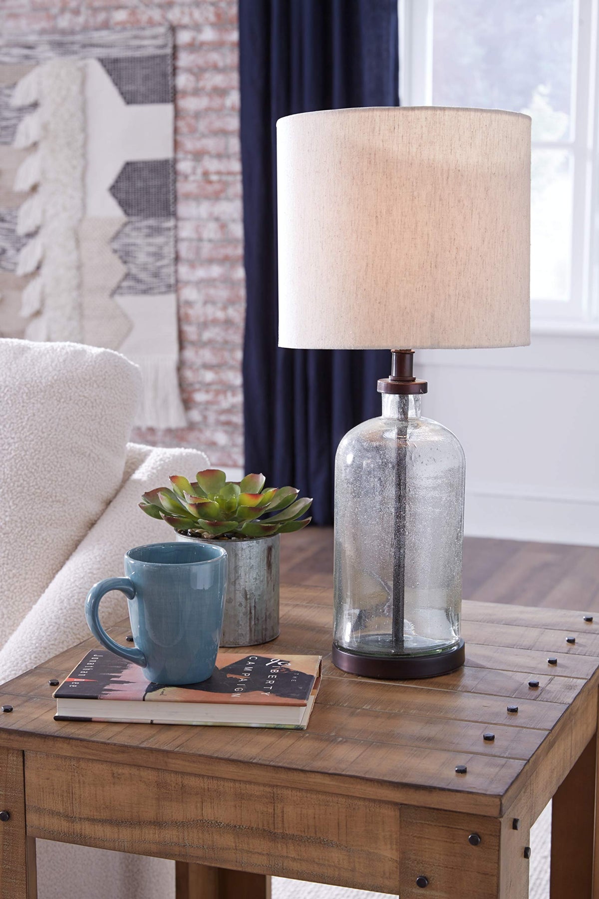 Bandile table lamp on a table provides warm ambient glow for bedrooms.