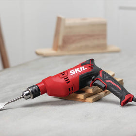 SKIL DL181901 drill shown with side-assist handle for safer, precise drilling