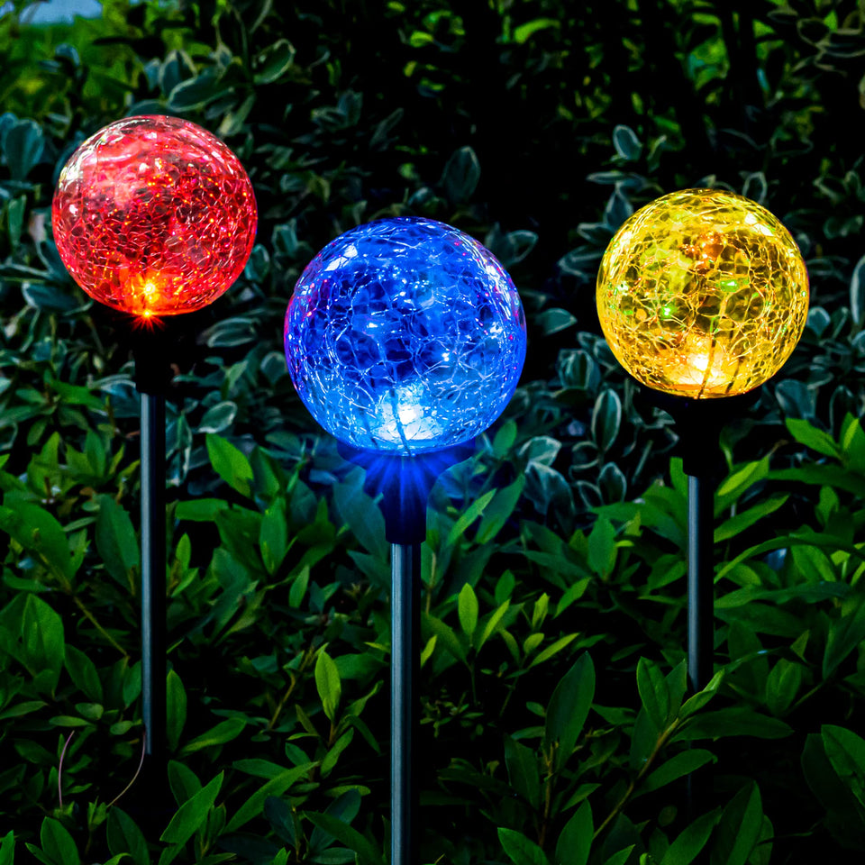SOLPEX solar globe light with cracked glass ball illuminating a garden walkway