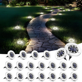 SOLPEX solar ground light disk on a lawn provides safe ambient illumination.