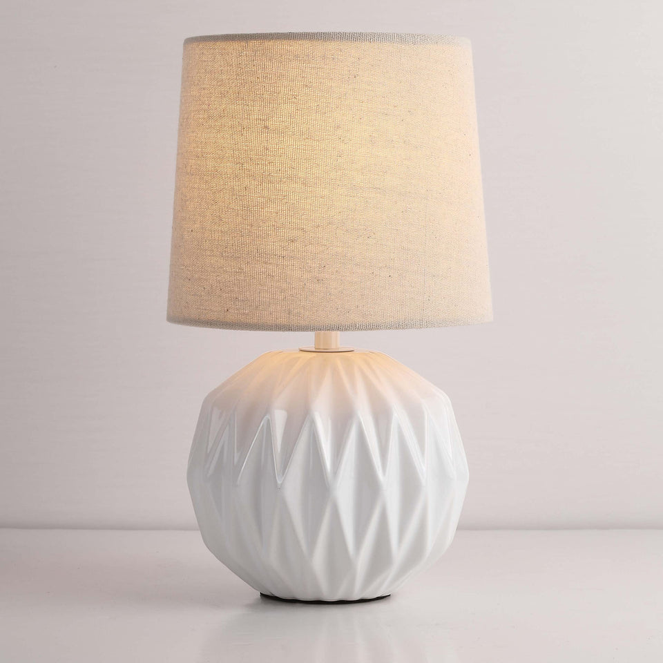 Somniferous white ceramic table lamp with linen shade for elegant bedside light.